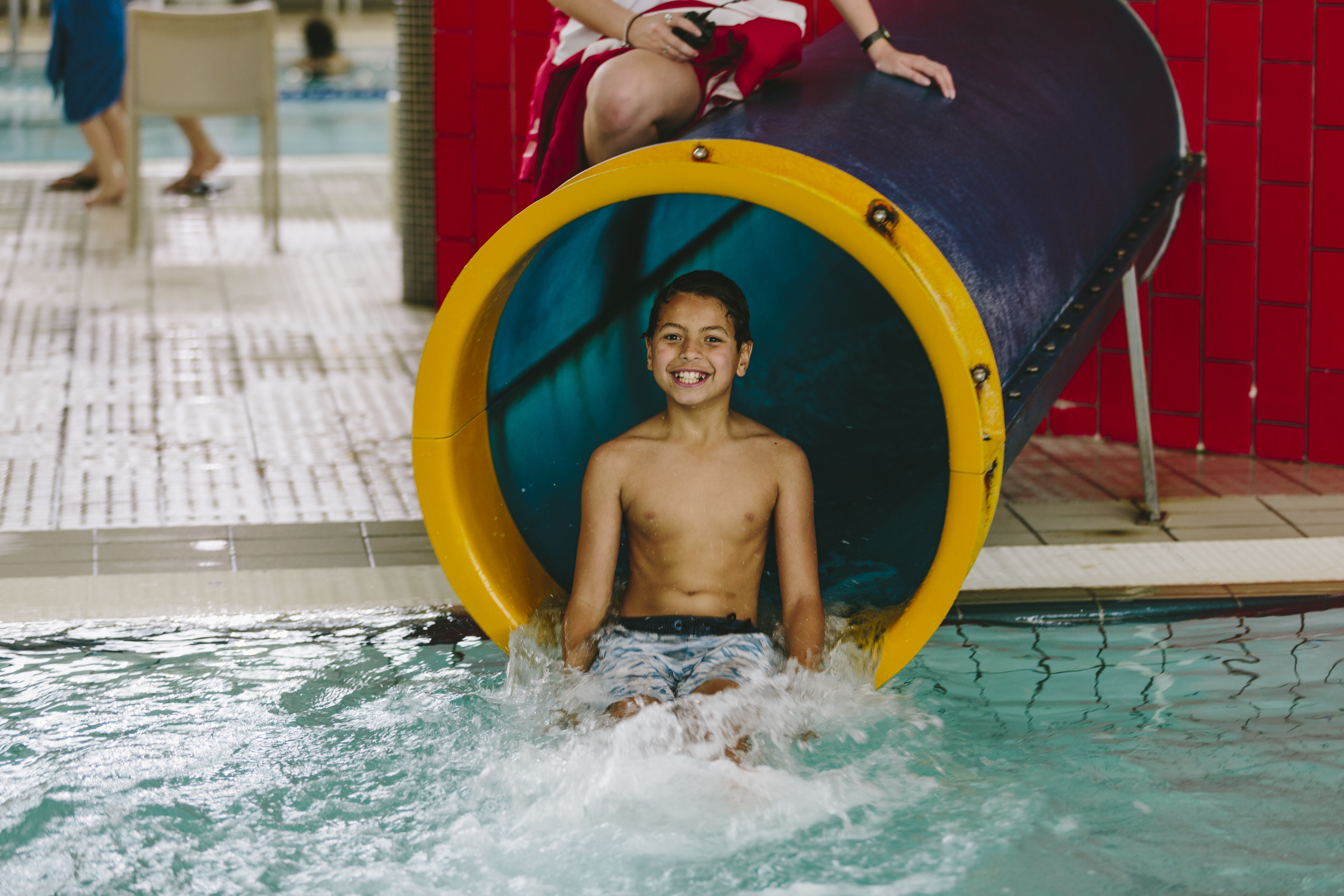 boy coming out of water slide 