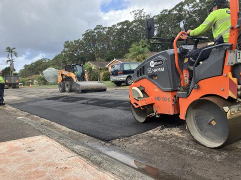 heavy machinery rolling new road pavement 