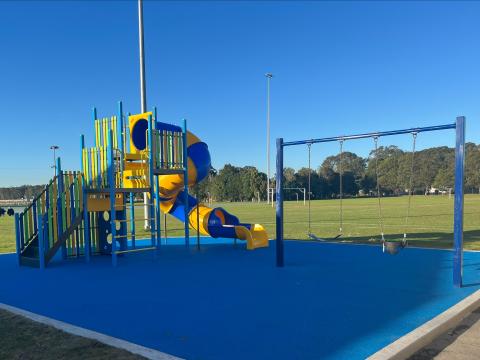Baker Park playspace with blue and yellow play unit and swingset