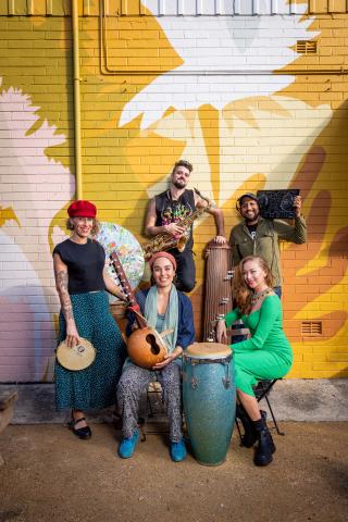 group of musicians in front of mural wall 