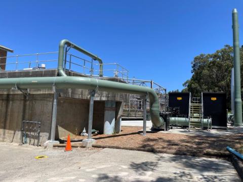 A large sewage treatment plant featuring extensive piping systems and a prominent main pipe structure.