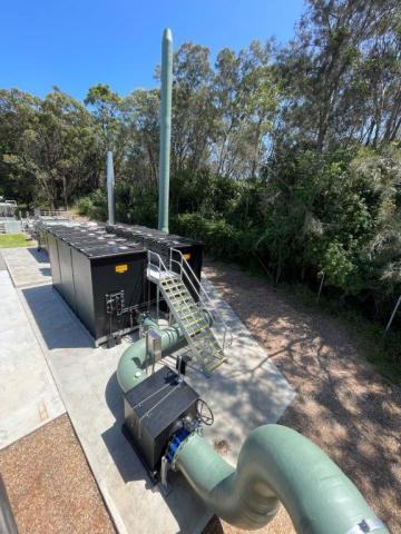 A large green pipe connected to a green hose, showcasing a robust and functional design for fluid transport.