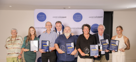 Group of men and woman holding awards 